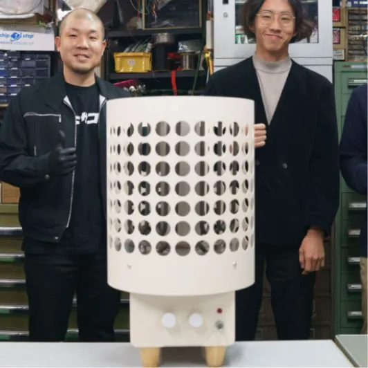 完成した家庭用サウナストーブを囲む2人の担当者