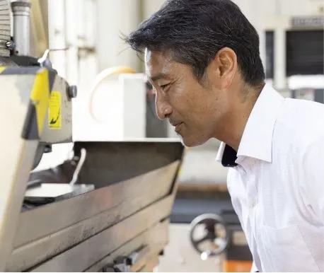 工作機械をのぞき込んで確認する男性